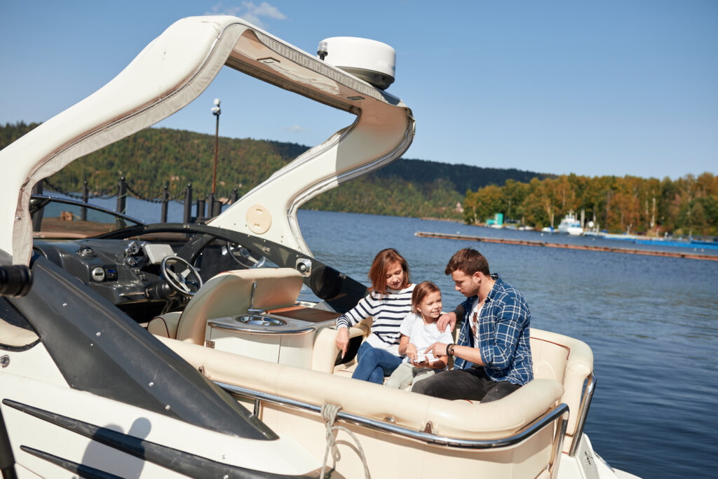 Family with daughter vacation together on sailboat in lake